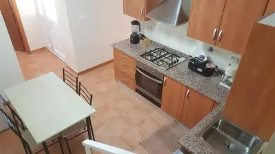 an overhead view of a kitchen with a stove and a table at Funchal - Breathtaking ocean & city view house in Funchal
