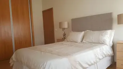a bedroom with a bed with white sheets and pillows at Funchal - Breathtaking ocean & city view house in Funchal