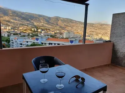 two glasses of wine on a table with a view at Funchal - Breathtaking ocean & city view house in Funchal