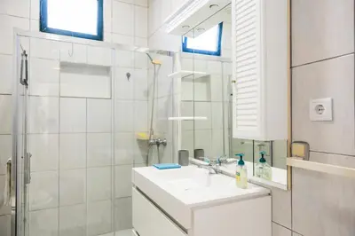 a white bathroom with a sink and a shower at Porto Santo Beach Side Oasis in Vila Baleira