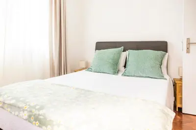 a bedroom with a white bed with green pillows at Porto Santo Beach Side Oasis in Vila Baleira