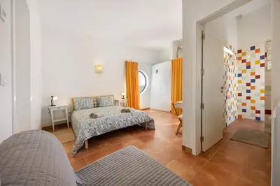 a bedroom with a bed and a hallway at Amado Properties in Carrapateira