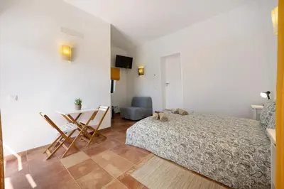 a bedroom with a bed with a blanket on it at Amado Properties in Carrapateira