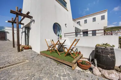 a white building with a wooden entrance to a door at Amado Properties in Carrapateira