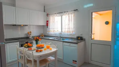 a bedroom with a bed and a table with flowers on it at Villa Frente Mar by ESCAPE to Madeira in Funchal