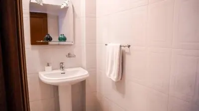 a white bathroom with a sink and a mirror at Villa Frente Mar by ESCAPE to Madeira in Funchal