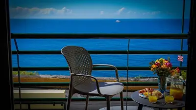 a table and chairs with a view of the ocean at Villa Frente Mar by ESCAPE to Madeira in Funchal