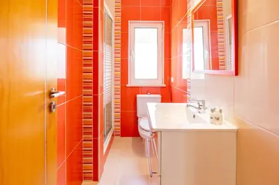 a bathroom with a toilet and a sink and a window at The Suites by The Lighthouse Arrifana in Aljezur
