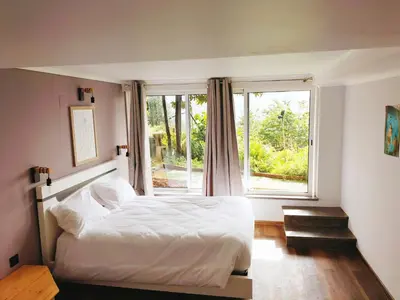 a bedroom with a white bed and a window at Jungle Lodge in Machico