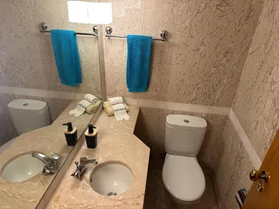 a bathroom with a sink and a toilet and blue towels at 2 Madeira Inn Group in Funchal
