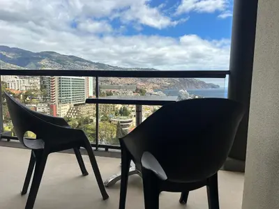 two chairs and a table on a balcony with a view at 2 Madeira Inn Group in Funchal