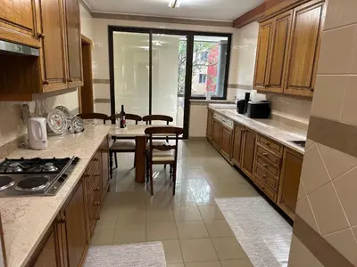 a kitchen with wooden cabinets and a table with chairs at 2 Madeira Inn Group in Funchal