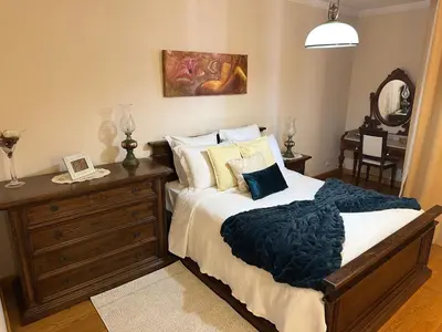 a bedroom with a bed and a dresser with a mirror at 2 Madeira Inn Group in Funchal