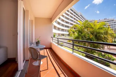 a balcony with a table and a view of a building at NÔNA Suite Funchal in Funchal