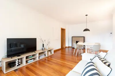 a living room with a television and a couch at NÔNA Suite Funchal in Funchal