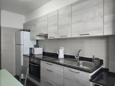 a kitchen with a sink and a refrigerator at The Infante Stay in Funchal