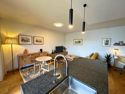 a kitchen with a sink and a living room at Colours by Madeira Best Apartments in Funchal