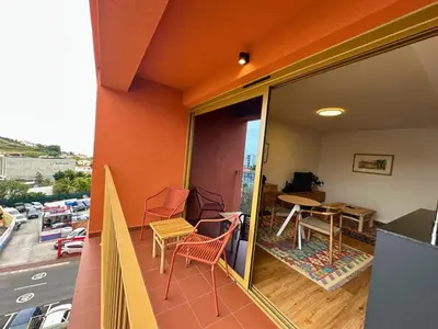 a balcony of a building with chairs and a table at Colours by Madeira Best Apartments in Funchal