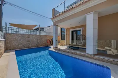 a house with a blue swimming pool next to a house at Bela Vista Exclusive Private Villa in Praia da Luz in Luz