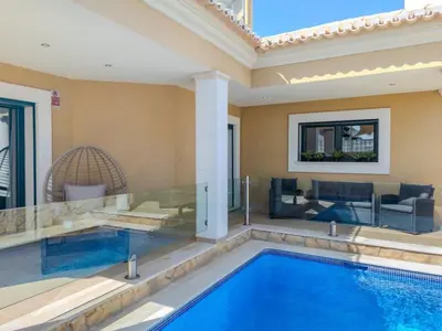 a swimming pool in a house with a living room at Bela Vista Exclusive Private Villa in Praia da Luz in Luz