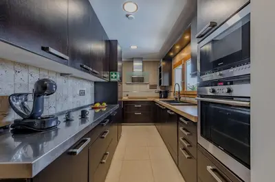 a kitchen with stainless steel appliances and brown cabinets at Bela Vista Exclusive Private Villa in Praia da Luz in Luz