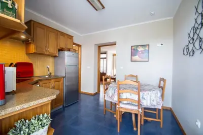 a kitchen with a table and chairs in a room at Casa da Avó - Vila do Porto in Vila do Porto