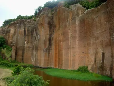 a large rock wall next to a body of water at Casa da Avó - Vila do Porto in Vila do Porto