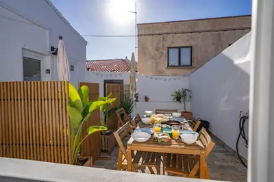 a table with food on it on a patio at Modern Old Town House with Sunny Terrace in Vila do Bispo