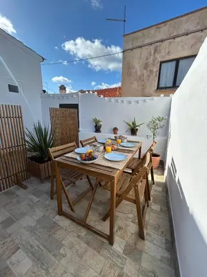 a wooden table and chairs on a patio at Modern Old Town House with Sunny Terrace in Vila do Bispo