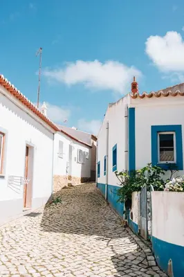 a cobblestone street in a town with white buildings at Modern Old Town House with Sunny Terrace in Vila do Bispo