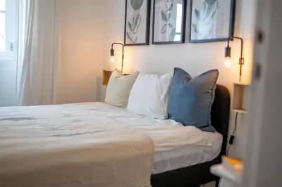 a bedroom with a bed with blue and white pillows at Modern Old Town House with Sunny Terrace in Vila do Bispo