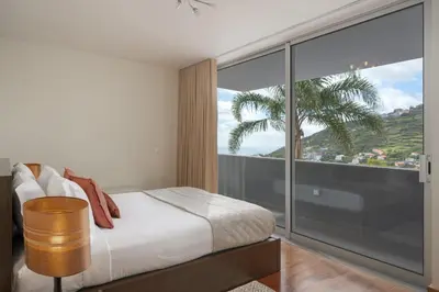 a bedroom with a bed and a large window at Private pool and sea view - Tropical Villa in Arco da Calheta