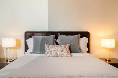 a white bed with pillows and two lamps at Private pool and sea view - Tropical Villa in Arco da Calheta