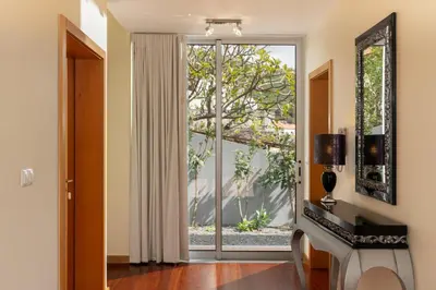 a living room with a large glass door at Private pool and sea view - Tropical Villa in Arco da Calheta