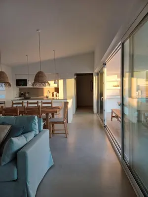 a living room with a blue couch and a kitchen at Casa Fá - NEW T4 - Aljezur in Aljezur