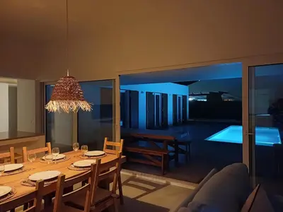 a dining room with a table with chairs and a room with a pool at Casa Fá - NEW T4 - Aljezur in Aljezur
