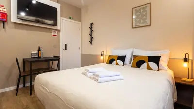 a bedroom with a white bed with towels on it at The Jolie - Porto Moniz Central Studios in Porto Moniz