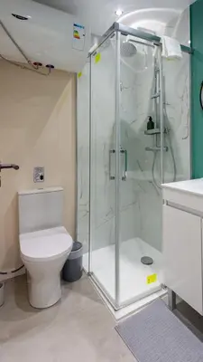 a bathroom with a toilet and a glass shower at The Jolie - Porto Moniz Central Studios in Porto Moniz