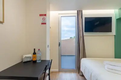 a room with a bed and a table with a window at The Jolie - Porto Moniz Central Studios in Porto Moniz