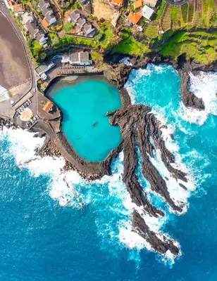 an aerial view of a beach with turquoise water at The Jolie - Porto Moniz Central Studios in Porto Moniz