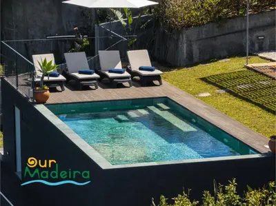 a swimming pool in a yard with chairs and an umbrella at Tranquil Villa Close to Facilities - NatureScape in Prazeres