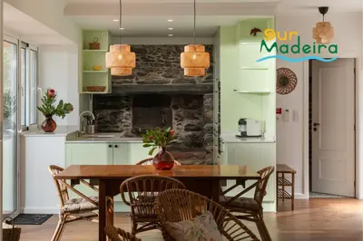 a kitchen with a wooden table and chairs at Tranquil Villa Close to Facilities - NatureScape in Prazeres