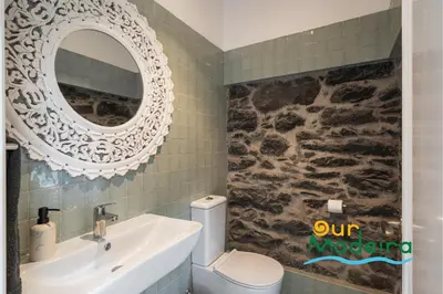 a bathroom with a sink and a mirror and a toilet at Tranquil Villa Close to Facilities - NatureScape in Prazeres
