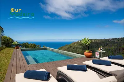a swimming pool with lounge chairs and the ocean at Tranquil Villa Close to Facilities - NatureScape in Prazeres