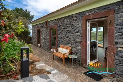 a stone house with a bench in front of it at Tranquil Villa Close to Facilities - NatureScape in Prazeres