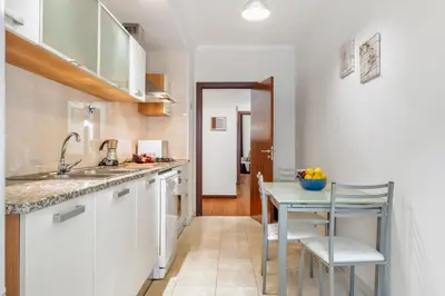 a kitchen with white cabinets and a small table at Madeira Emotions II, By OP in Funchal