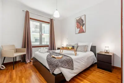a bedroom with a large bed and a chair at Madeira Emotions II, By OP in Funchal