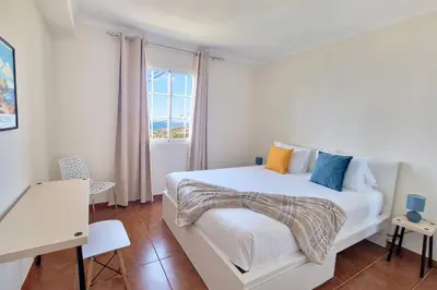 a bedroom with a white bed and a window at Desertas Vista Ninho by LovelyStay in Gaula