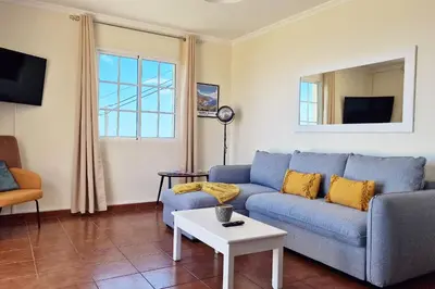 a living room with a blue couch and a table at Desertas Vista Ninho by LovelyStay in Gaula