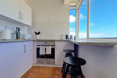 a kitchen with a counter and two stools in it at Desertas Vista Ninho by LovelyStay in Gaula